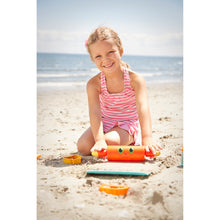 Girl playing with sand castle toys