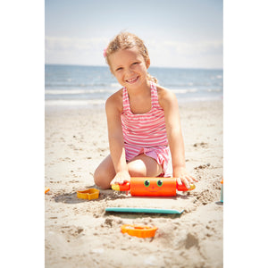 Girl playing with sand castle toys