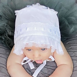 Top view of baby wearing White Ribbon Baby Bonnet.